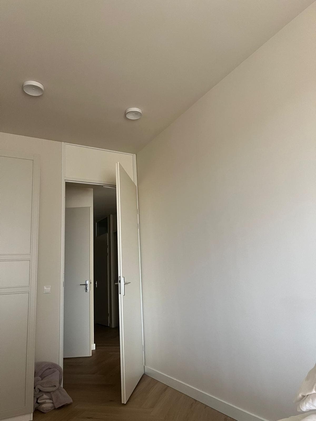 Licht geschilderde kamer met strak afgewerkte wanden, plafond, deur en kozijn